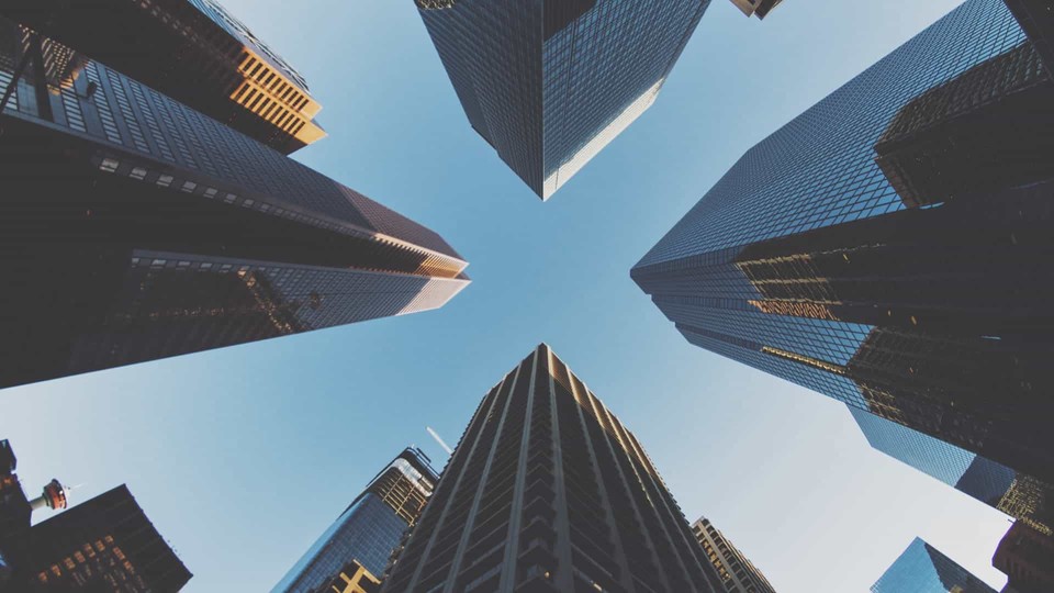 corporate buildings from the ground up to the top with blue sky